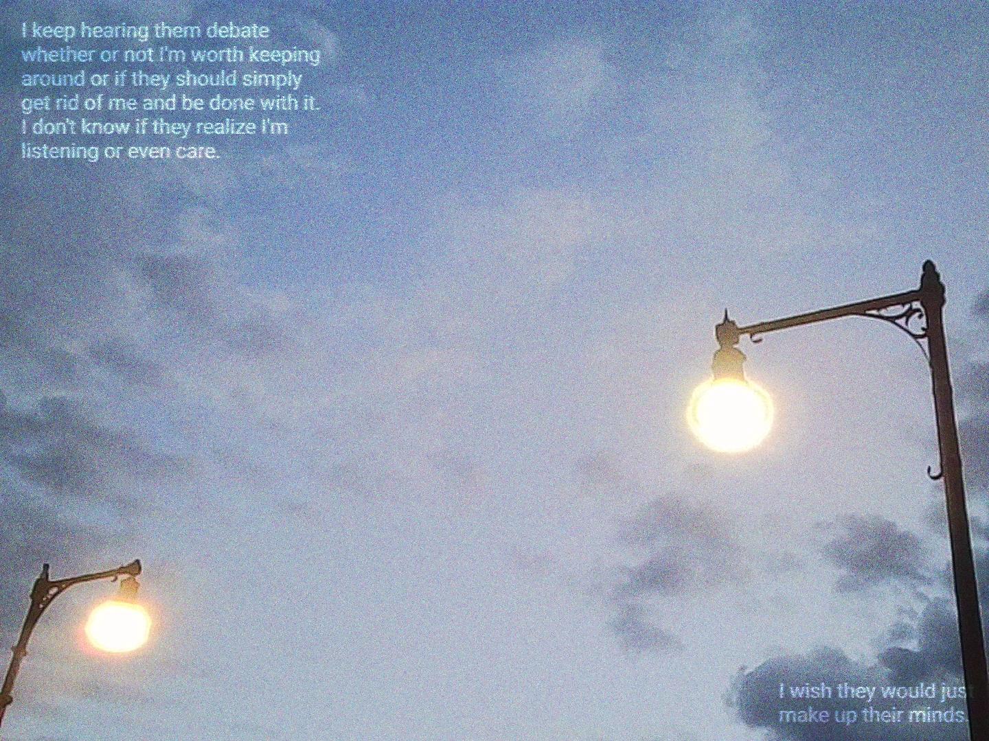 A static-filled photo of lamp post at dawn. Glowing text in the top left reads "I keep hearing them debate whether or not I'm worth keeping around or if they should simply get rid of me and be done with it. I don't know if they realize I'm listening or even care." More text in the bottom right reads "I wish they would just make up their minds."
